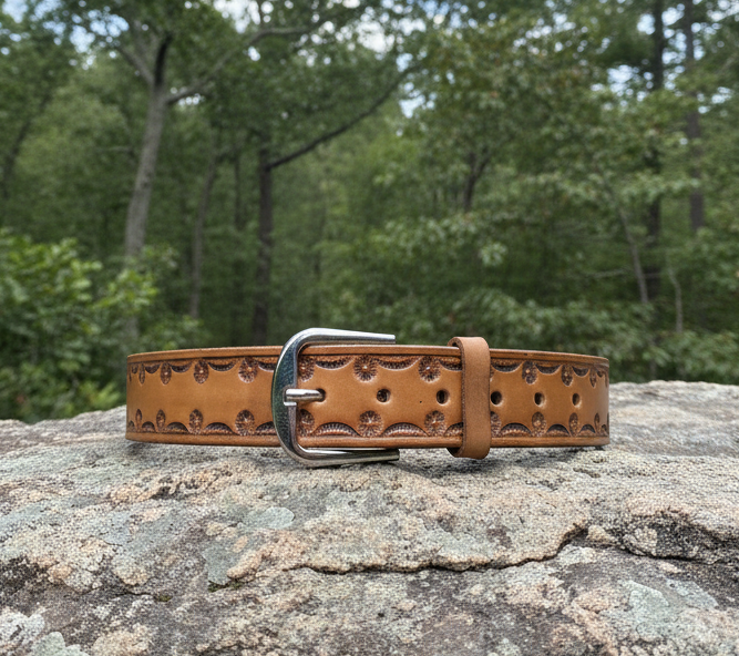 Custom Tooled brown belt resting on a rock - The Leather Wizard 